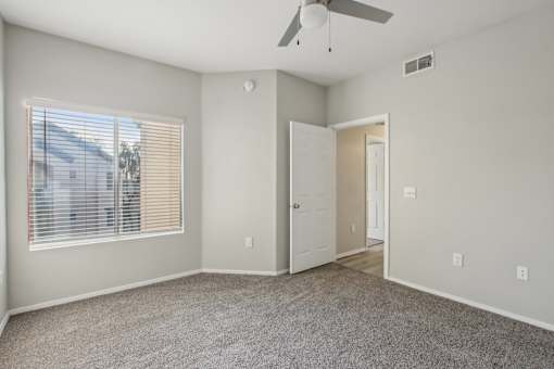 A room with a ceiling fan and a window with blinds at Sweetwater At Metro North Apartments, Phoenix, AZ 85029