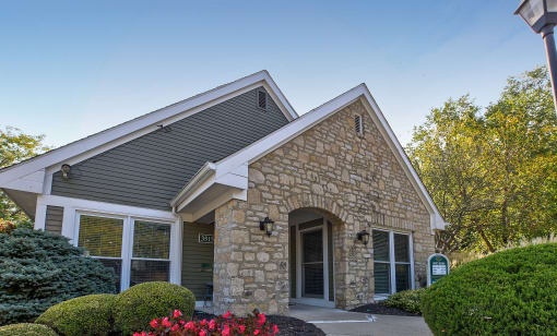 an exterior view of a stone building with a driveway and trees at Brookstone Village, Cincinnati