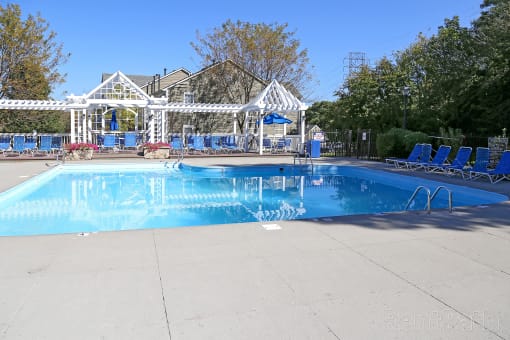 a swimming pool with chairs around it and a house in the background at Brookstone Village, Cincinnati