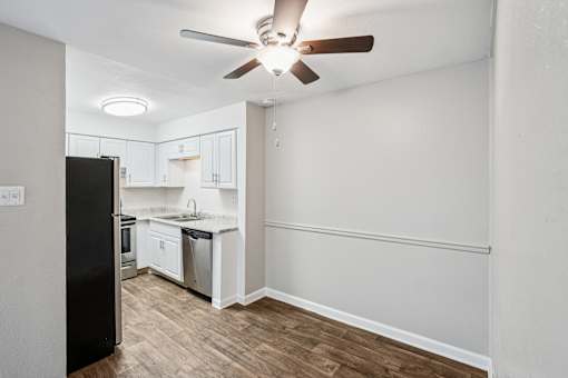 A kitchen with a black refrigerator and wooden floors. at Glen at Lakewood, Lakewood