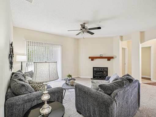 A living room with a grey couch, a coffee table, and a fireplace. at Cedar Springs Apartments, Raleigh, North Carolina