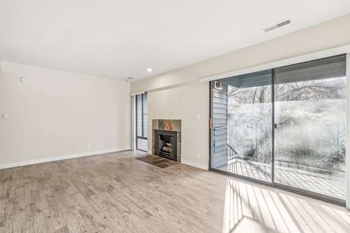 A large, empty room with a fireplace and a view of a snowy landscape outside. at Cliffs at Canyon Ridge, Utah, 84401