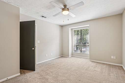 A room with a ceiling fan and a door. at Canopy Glen, Norcross, Georgia