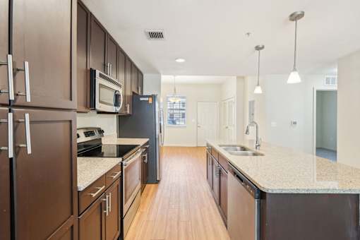 A kitchen with brown cabinets and a black refrigerator. at The Dakota, Jupiter, Florida