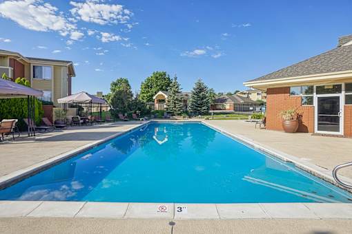 A swimming pool in a residential area with a clear blue sky.