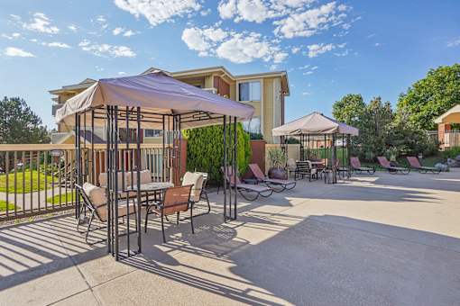 A patio area with a table and chairs under a canopy.