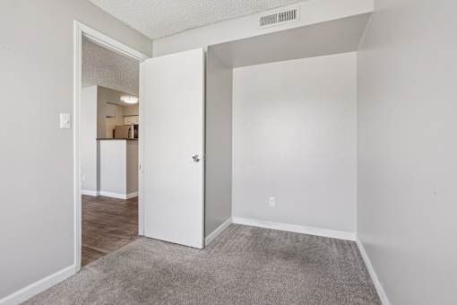 A white door is open to a hallway. at Windmill Apartments, Colorado