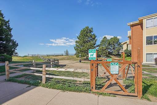 A wooden gate with a sign on it in front of a building.