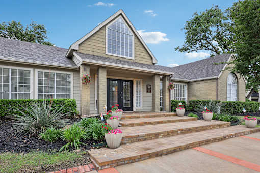 A house with a front yard and steps leading to the front door.