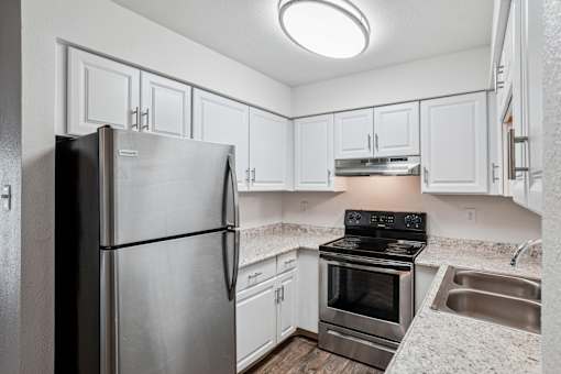A kitchen with a stainless steel refrigerator and stove. at Glen at Lakewood, Lakewood, Colorado