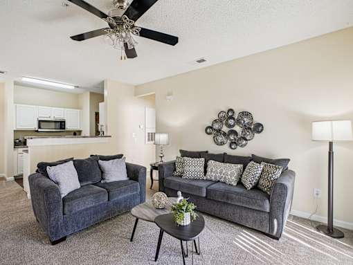A living room with two couches and a ceiling fan. at Cedar Springs Apartments, Raleigh, 27609