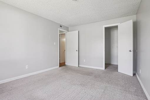 A room with two doors and a carpeted floor. at Windmill Apartments, Colorado, 80916