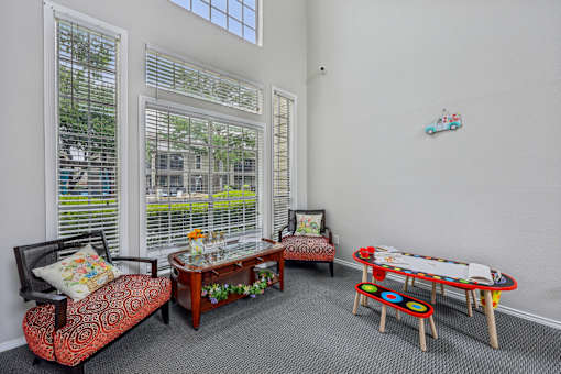 A living room with a sofa, a table, and a window with blinds.