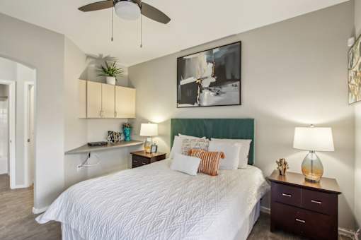 A bedroom with a large bed and a ceiling fan at Sweetwater At Metro North Apartments, Phoenix