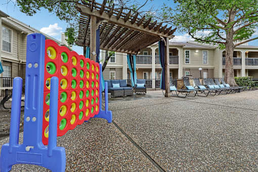 A large blue and red foosball table in the middle of a courtyard.
