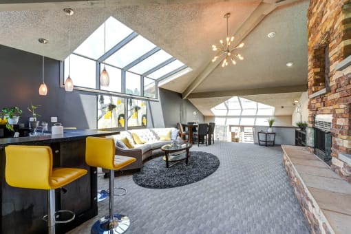 Clubhouse with a bar with yellow chairs and fireplace  at Union Heights Apartments, Colorado Springs, CO
