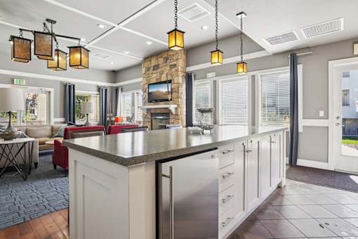 A kitchen with a large island and a stone backsplash. at Deer Crest Apartments, Broomfield
