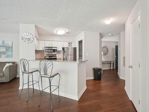 A kitchen with a bar area and two chairs. at University Ridge Apartments, Durham, NC
