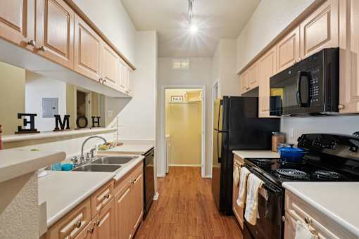 A kitchen with wooden cabinets and black appliances. at Heritage at Stone Mountain, Colorado, 80233