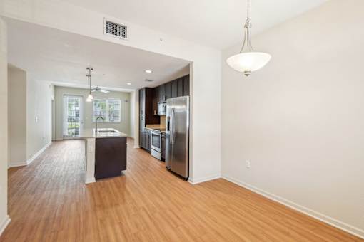 A kitchen with a refrigerator, sink, and wooden floors. at The Dakota, Florida
