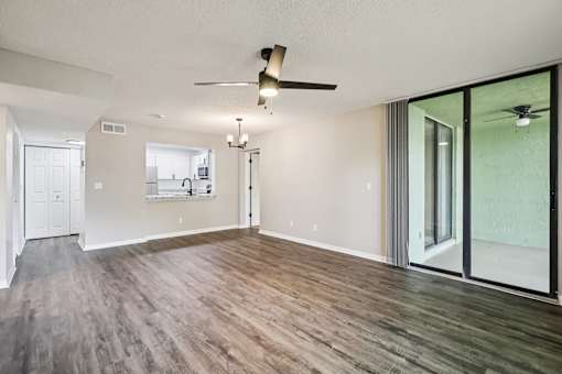 A room with a ceiling fan and sliding glass doors. at Lakeside Glen Apartments, Melbourne, 32904