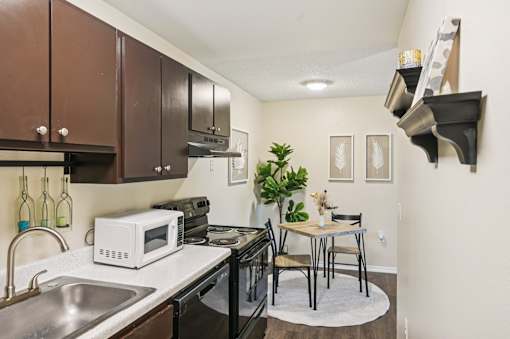 A kitchen with a white microwave on the counter. at Sarasota South Apartments, Bradenton