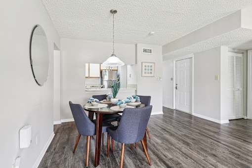 A dining room with a round mirror on the wall. at Lakeside Glen Apartments, Florida