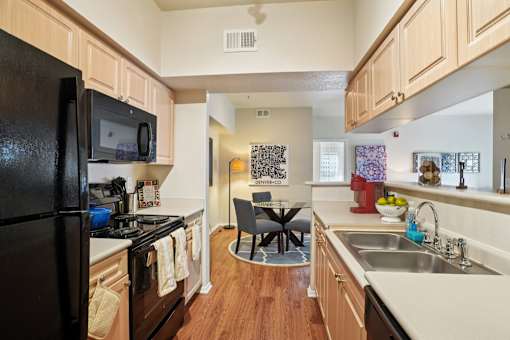 A kitchen with a black refrigerator and a sink. at Heritage at Stone Mountain, Northglenn, 80233