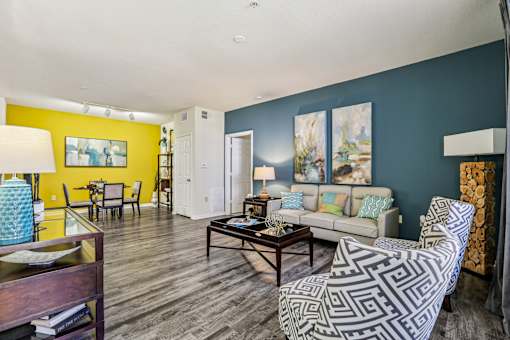 Living room with teal wall and geometric patterned chair at The Arbor Walk Apartments, Tampa