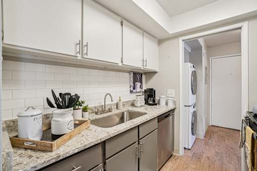 A kitchen with a white fridge and a marble counter top.