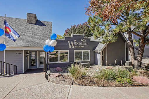 A house with a sign that says Windmill in front of it. at Windmill Apartments, Colorado Springs, Colorado