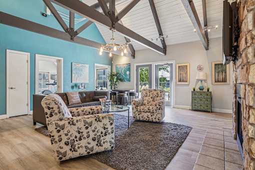 A living room with a brown sofa and two chairs with floral patterns. at Windmill Apartments, Colorado