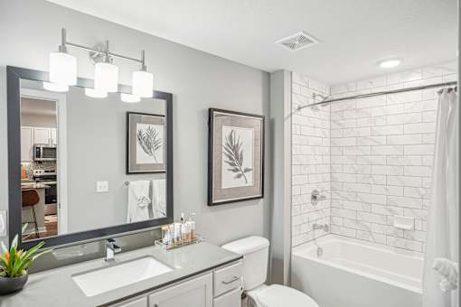 a white bathroom with a shower and a sink and a mirror at Edge75, Naples, Florida 34104