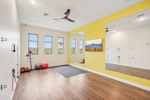 a workout room with a ceiling fan and mirrors on the wall at Edge75, Naples, Florida 34104