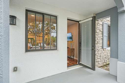 the entrance to a home with a large window and a patio at Edge75, Naples, Florida 34104