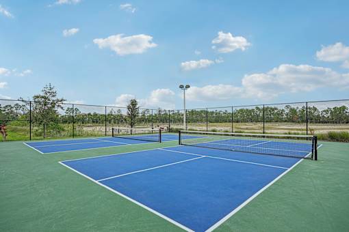 a blue and green tennis court on a sunny day at Edge75, Naples, Florida 34104