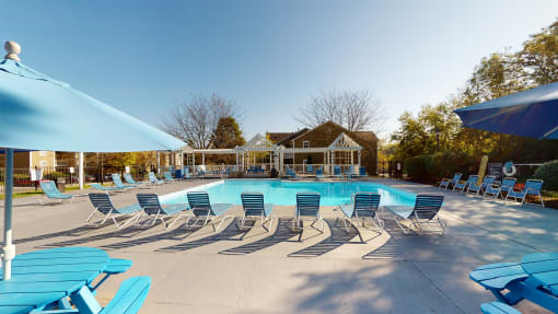 the resort style pool is surrounded by chairs and umbrellas at Brookstone Village, Cincinnati