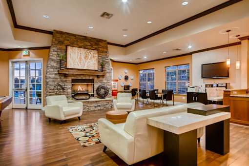 a large living room with a fireplace and a table at Heritage at Stone Mountain, Northglenn, CO, 80233