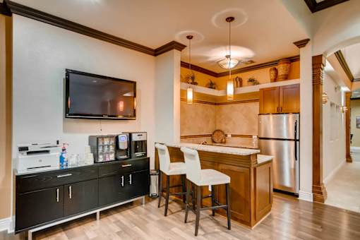 a kitchen with a bar and a refrigerator and a tv at Heritage at Stone Mountain, Northglenn, CO, 80233