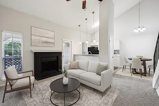 A living room with a fireplace, a couch, a chair, and a coffee table at The Willows on Rosemeade, Dallas, TX 75287