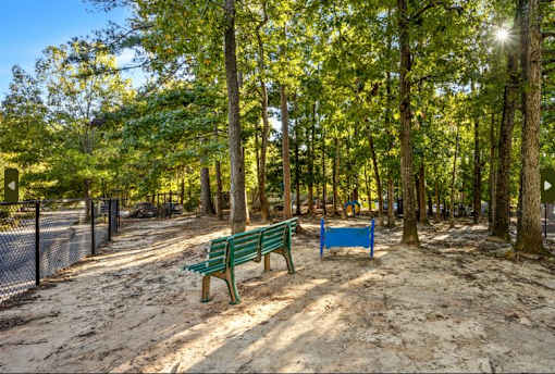 Dog park with wo benches in a park with trees at University Ridge Apartments, Durham, NC, 27707