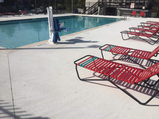 Row of red  chairs next to a swimming pool at River Crossing Apartments, Thunderbolt, GA, 31404