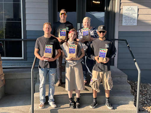 A group of people stand outside a leasing office holding certificates at Cliffs at Canyon Ridge, Ogden, UT, 84401
