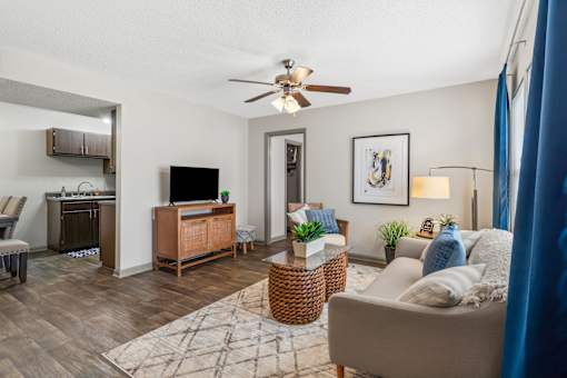 Living room with a couch and a chair and a ceiling fan at Lofts of Wilmington, Wilmington, NC