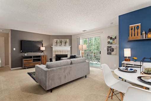 Living room with a couch and a table and a television at University Ridge Apartments, Durham, NC, 27707