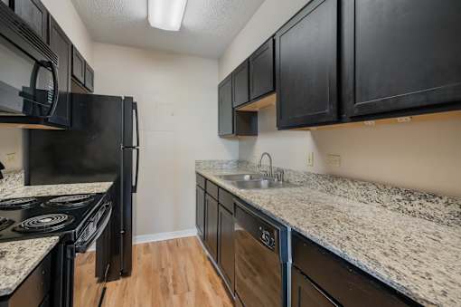 Kitchen with black appliances at Esplanade at City Park, New Orleans, LA