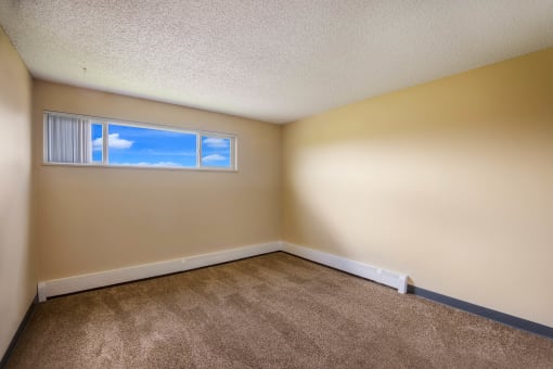 a bedroom with beige walls and a window at Broadmoor Springs, Colorado Springs, CO, 80906