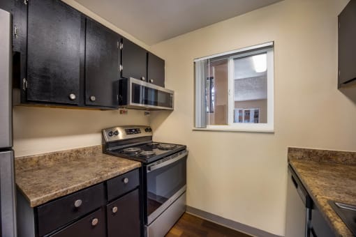 a kitchen with a stove top oven next to a window at Broadmoor Springs, Colorado Springs, CO, 80906
