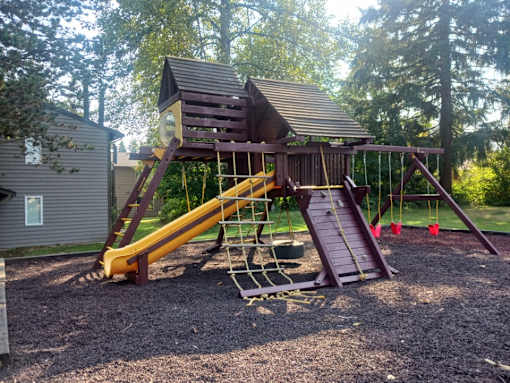 A wooden playground structure with a yellow slide at North Creek Apartments, Everett, Washington, 98208