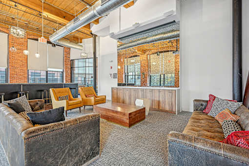 a living room with couches and chairs and a table at Riverwalk Apartments, Lawrence, MA